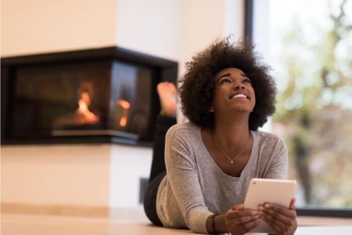 Black lady lying on the floor smiling - Does Postinor 2 work during ovulation