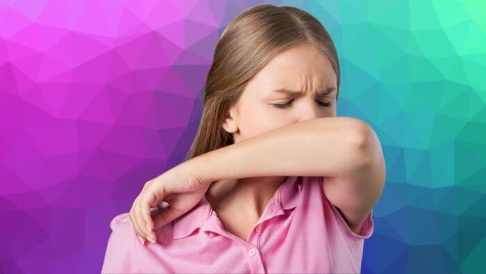 Lady coughing into a bent elbow - reduces the spread of Covid-19