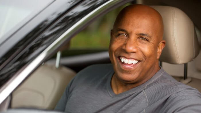 Smiling man of african origin seating in a car