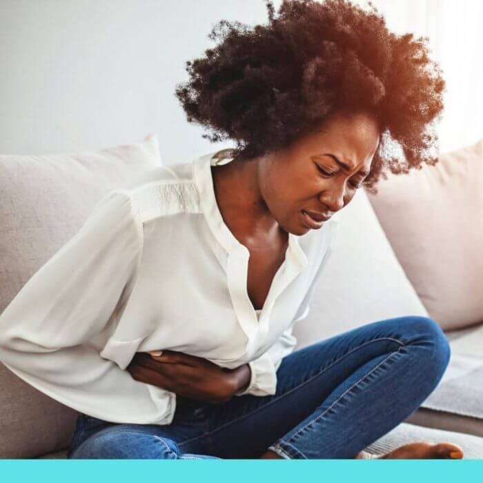 African lady bent over in pain - Who gets Endometriosis?