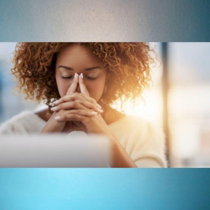 Lady with hands folded in front of her face
