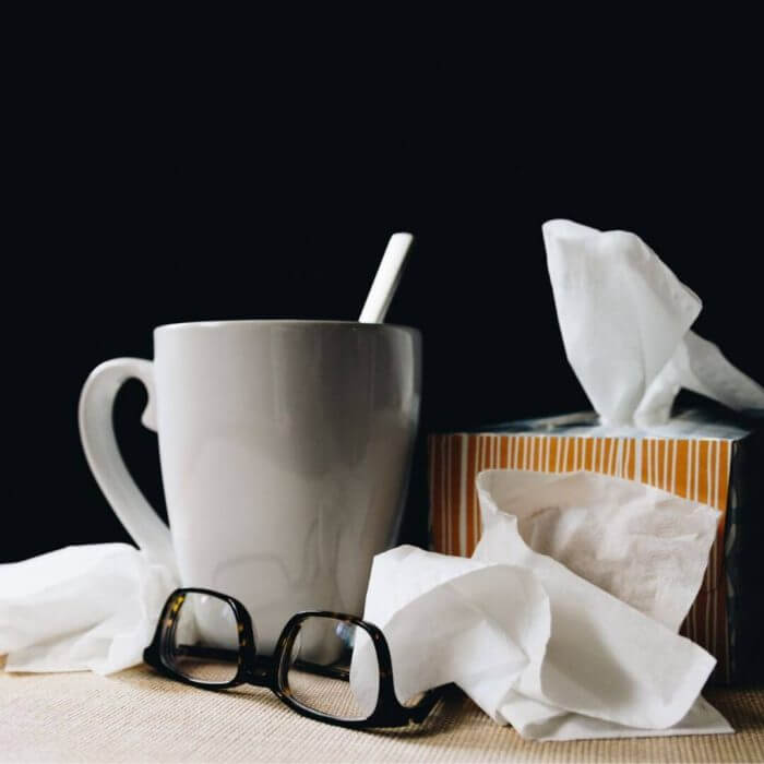 Mug, glasses and a box of tissues are the sick person's best friend.