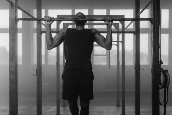 kickstart your fitness journey - fit man in black work out gear doing pull ups