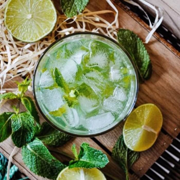 Cup of light green liquid made from sliced lemons