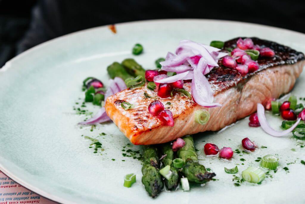 A dish of steamed fish topped with sliced red onions