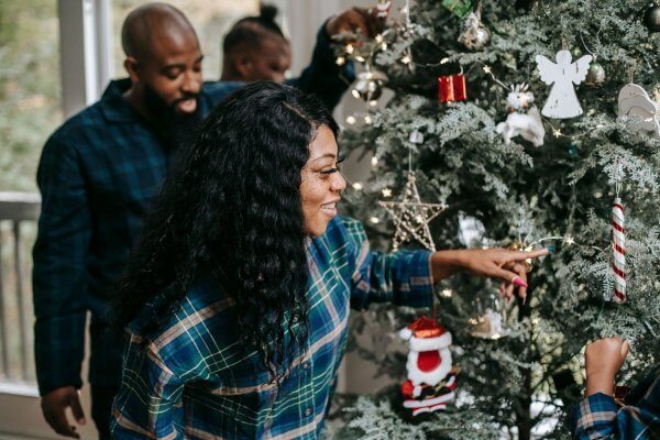 Pregnant u delegating others decorating the tree At Christmas