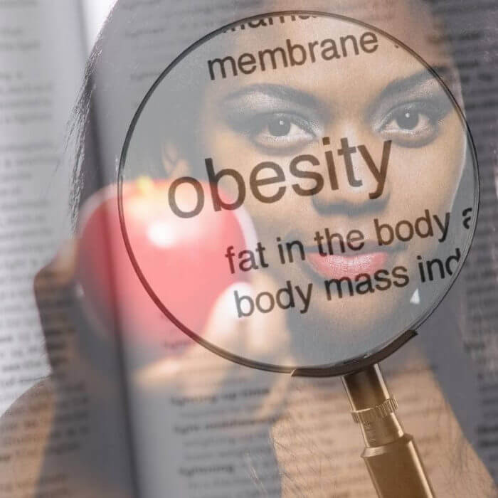 Obesity defined on a background of a young african girl holding out an apple