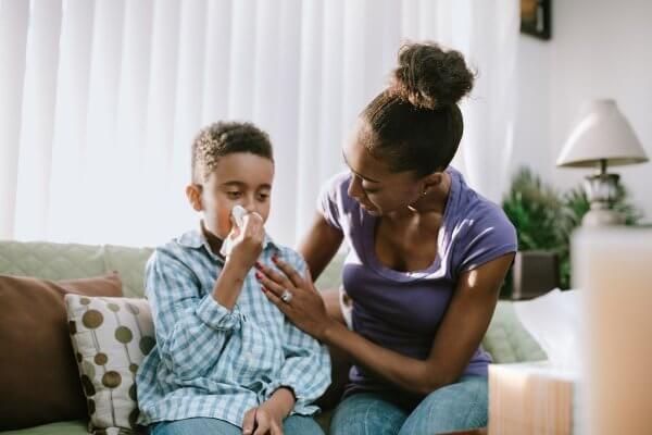 Group A Streptococcus - mum helping boy to blow his nose.