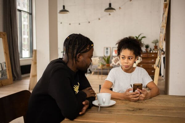 Dad and daughter of African background sitting a table - all parents should be able to talk to your kids about sex