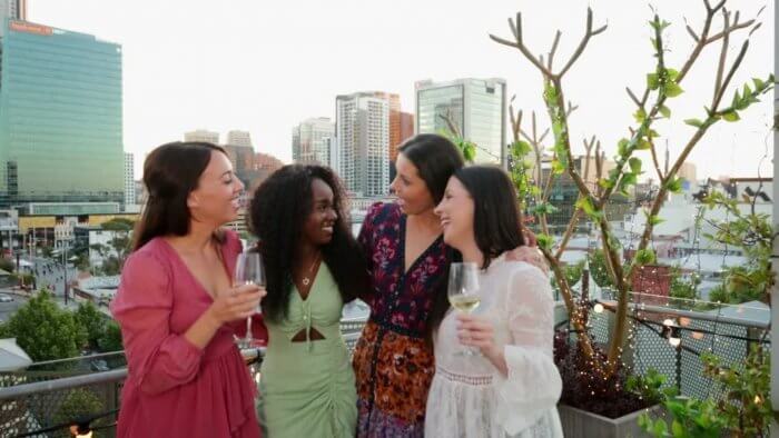 heart healthy diet - group of ladies in evening wear chatting and takng cocktail drinks