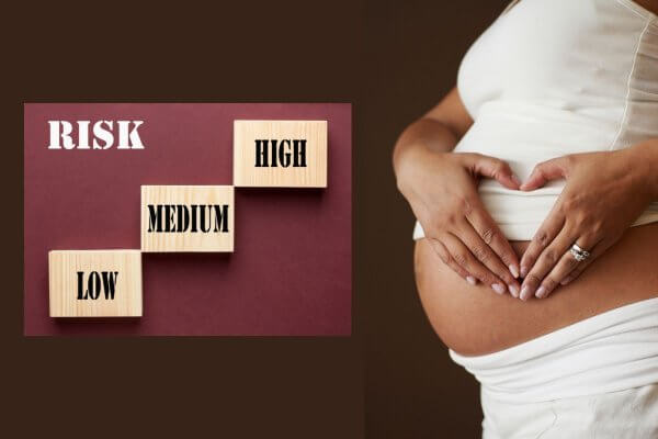 Black lady in white crop top making a heart shape in front of her exposed bump