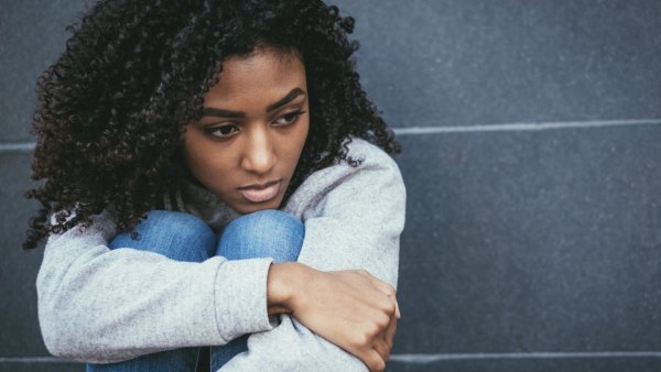 Young african girl looks worried about excessive bleeding after emergency birth control