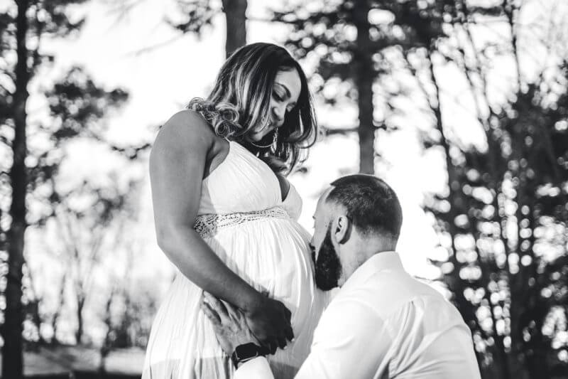 Dealing with Covid-19 in Pregnancy - man kissing abdomen of is pregnant wife