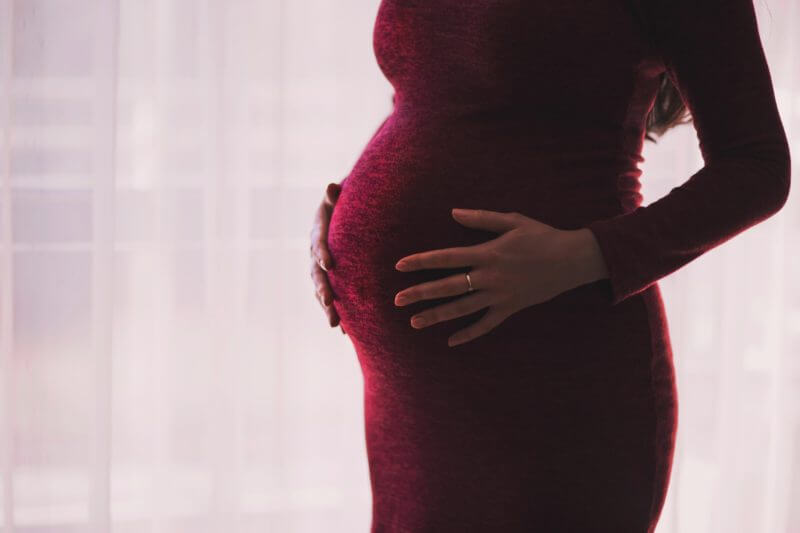 Pulmonary Embolism cn happen in women who are pregnant or just delivered- heavily pregnant woman in a rich closefitting red dress.