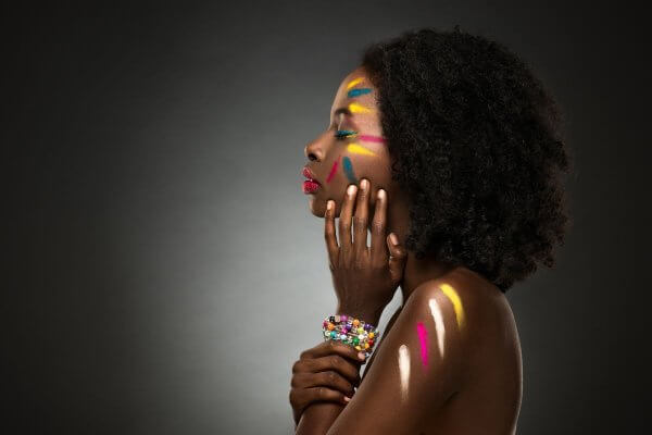 Profile of pretty dark skinned African lady with colourful face and shoulder markings - increased blood flow and circulation improves your skin appearance and health