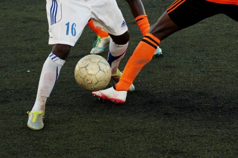 Football injuries - 2 players' legs kicking a football