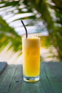 Clear drinking glass filled with yellow liquid  soft drink 