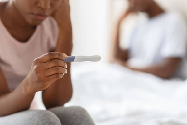 Blac Couple Appearing Dismayed by a pregnancy test result