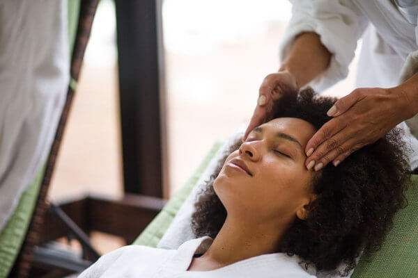 Stress relief is a key solution to unwanted weight - african lady having a temple massage