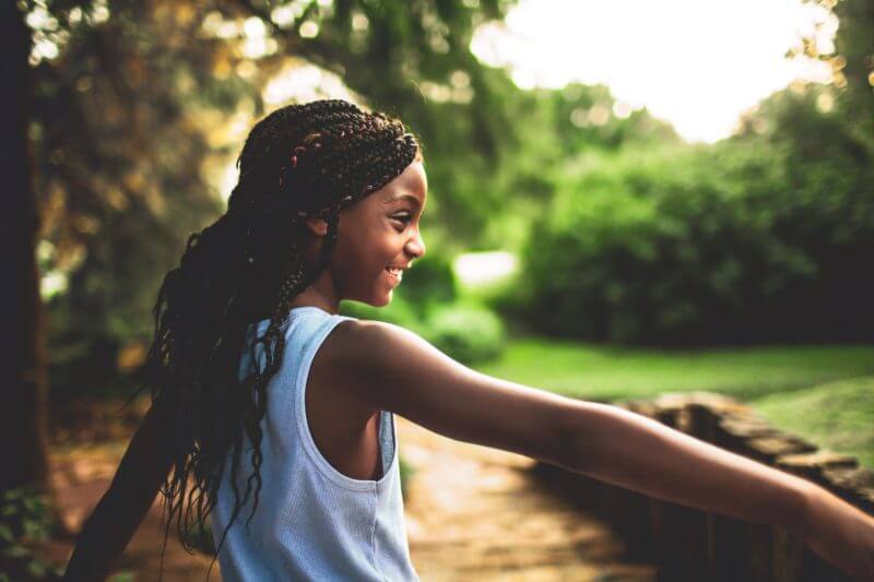 Young child of african background holding her arm stretched out - image for coughs in children.